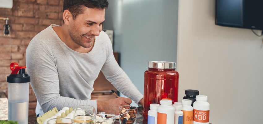 Dark-haired sportsman making a list of dietary supplements