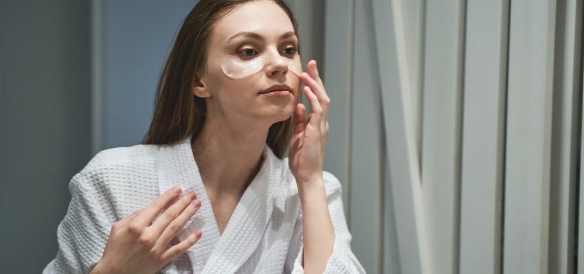Lady moisturizing her skin under the eyes